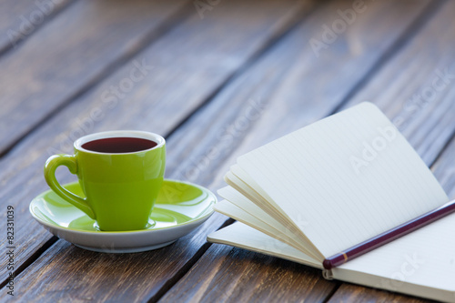 Cup of coffee and notebook with pencil