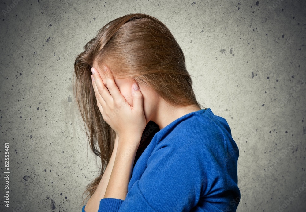 Despair. One sad woman sitting on the floor near a wall and Despair. One sad woman sitting on the floor near a wall and
