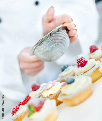Chef hands decorating cupcakes