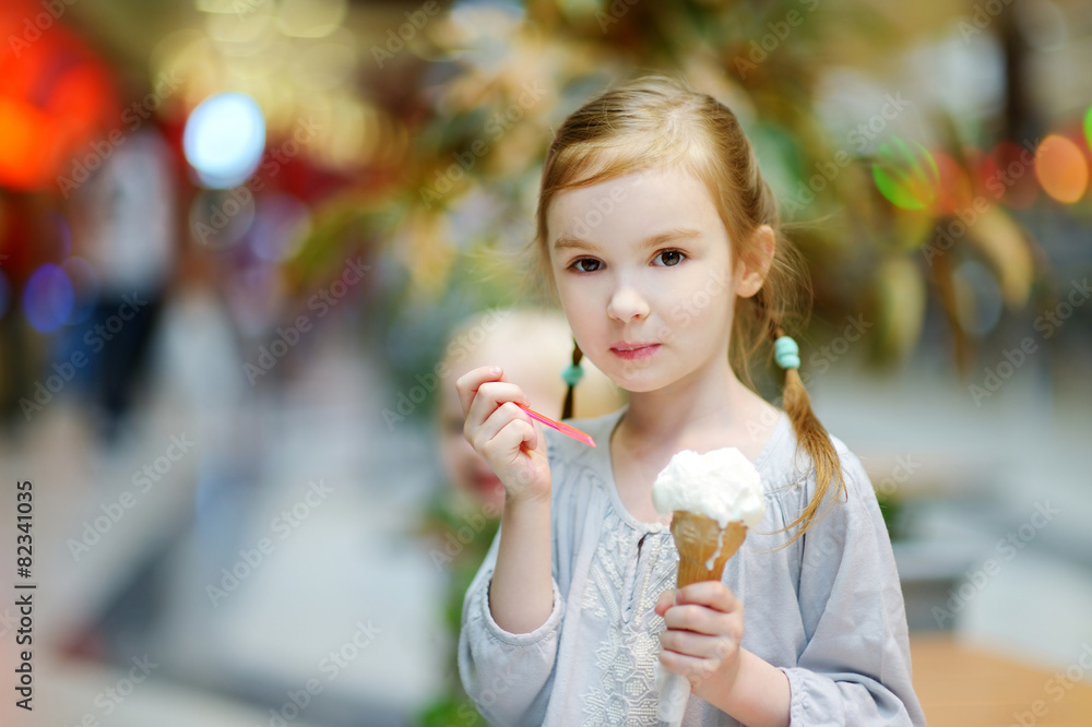 Adorable little girl eating ice-cream outdoors
