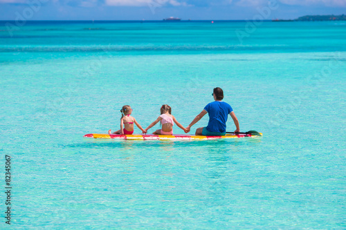 Father and kids on surfboard during summer vacation