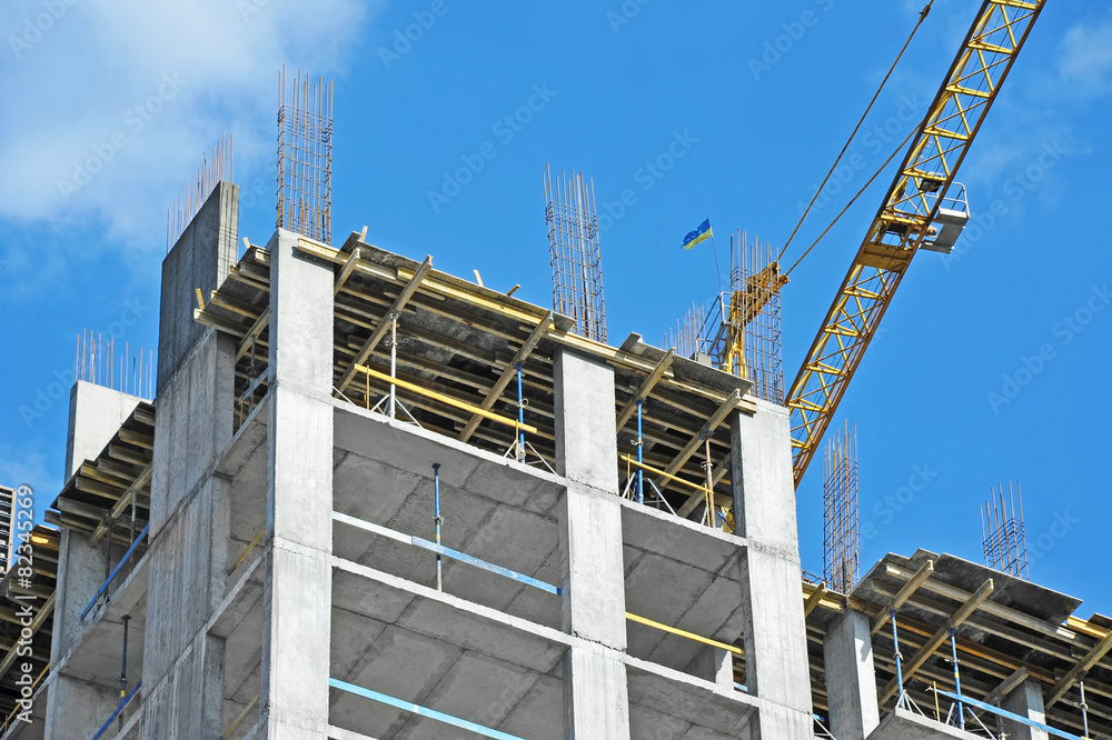 Crane and building construction site against blue sky Crane and building construction site against blue sky