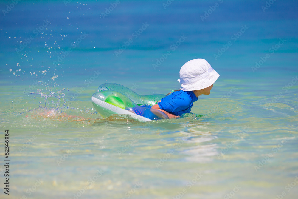 Adorable little girl playing in shallow water on white beach Adorable little girl playing in shallow water on white beach