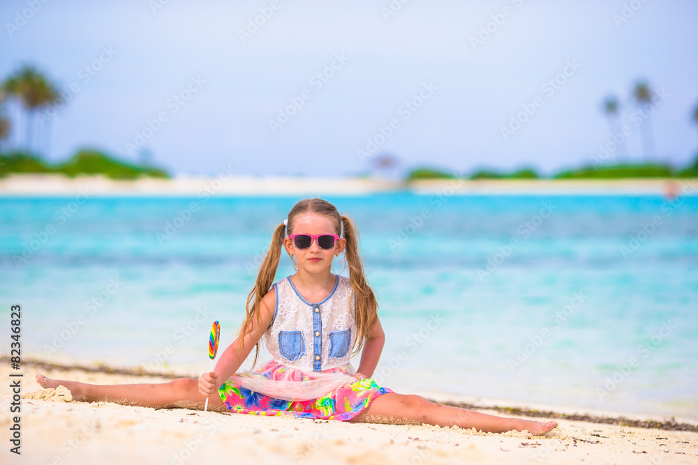 Little girl have fun with lollipop on the beach