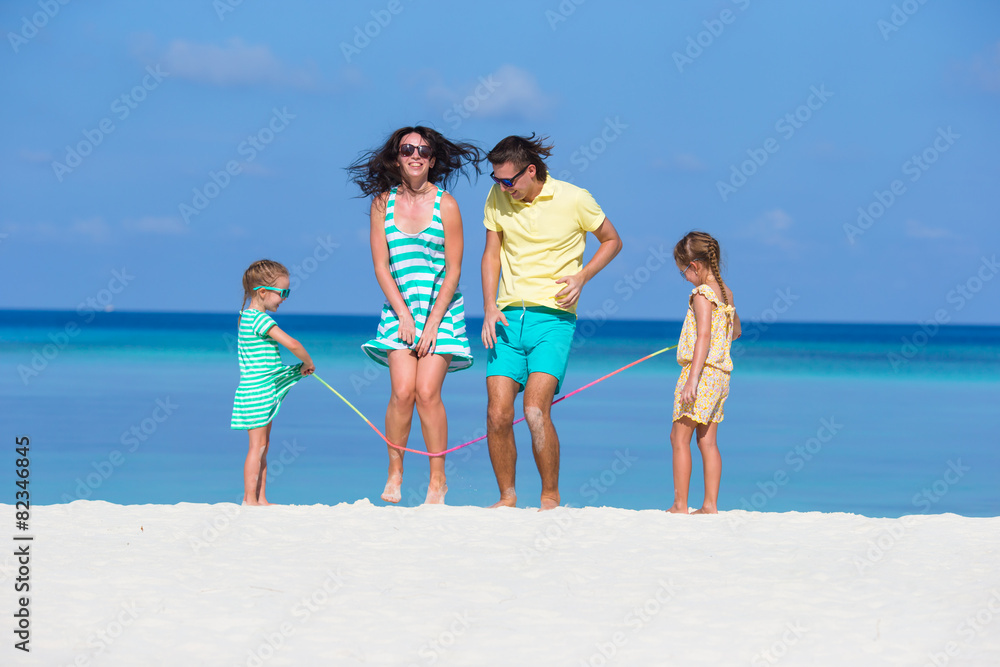 Happy family playing together on white beach