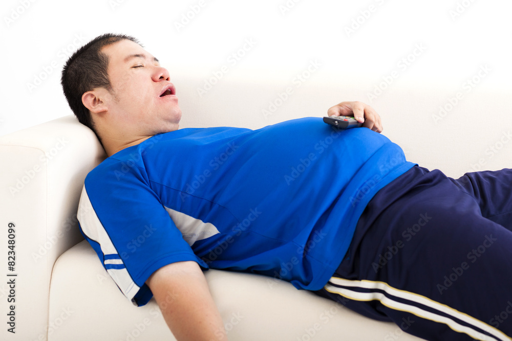 fat man sleep on the sofa and holding tv remote control fat man sleep on the sofa and holding tv remote control