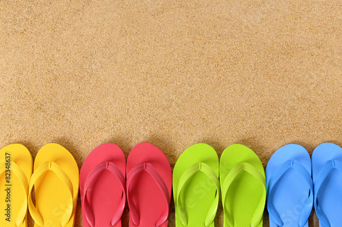 Flip flops or flipflop in a row on a sandy summer holiday vacation beachsand background photo