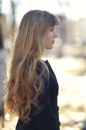 portrait of a girl with long blond hair outside in the spring photo