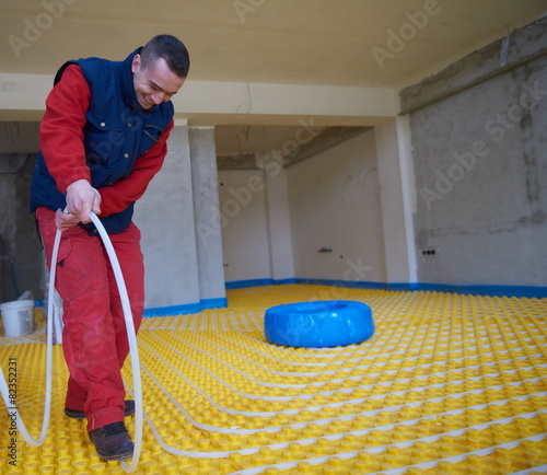 workers installing underfloor heating system photo