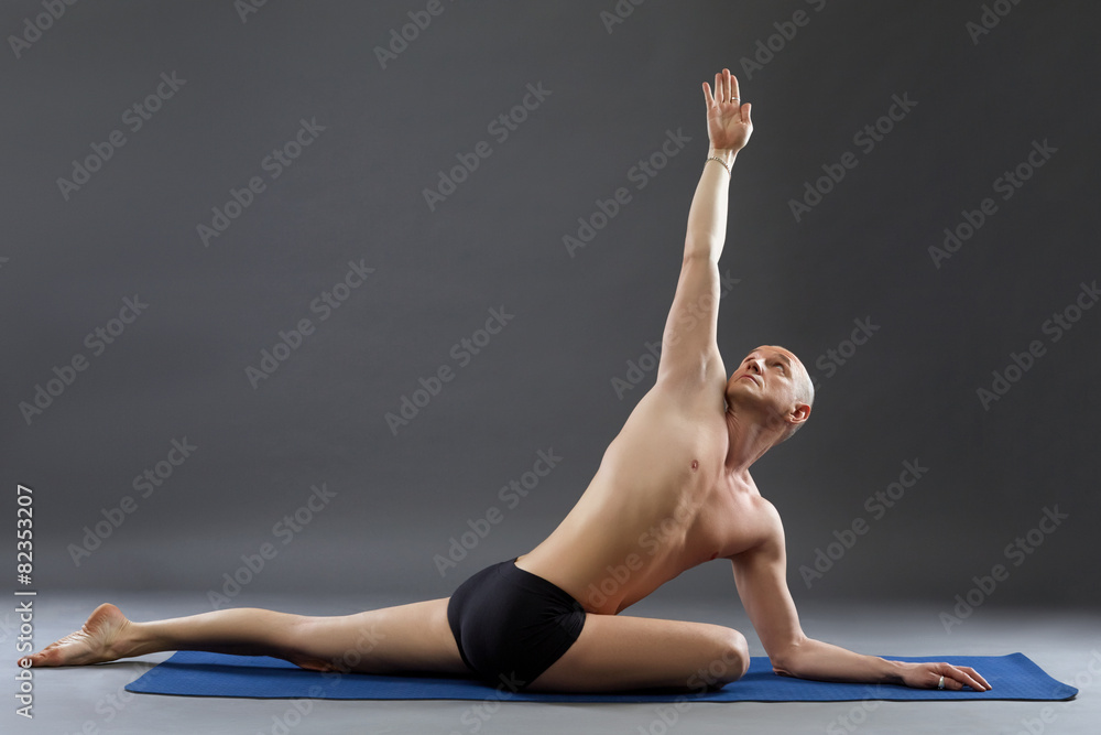 Studio shot of middle-aged man practicing yoga