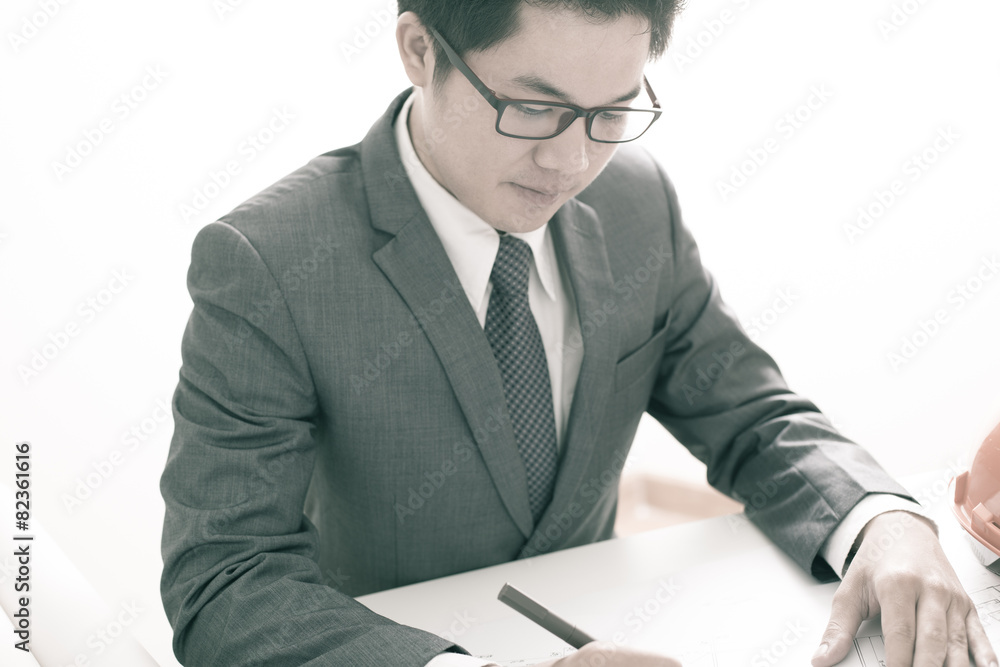 Closeup cropped image of a young male architect working on bluep Closeup cropped image of a young male architect working on bluep
