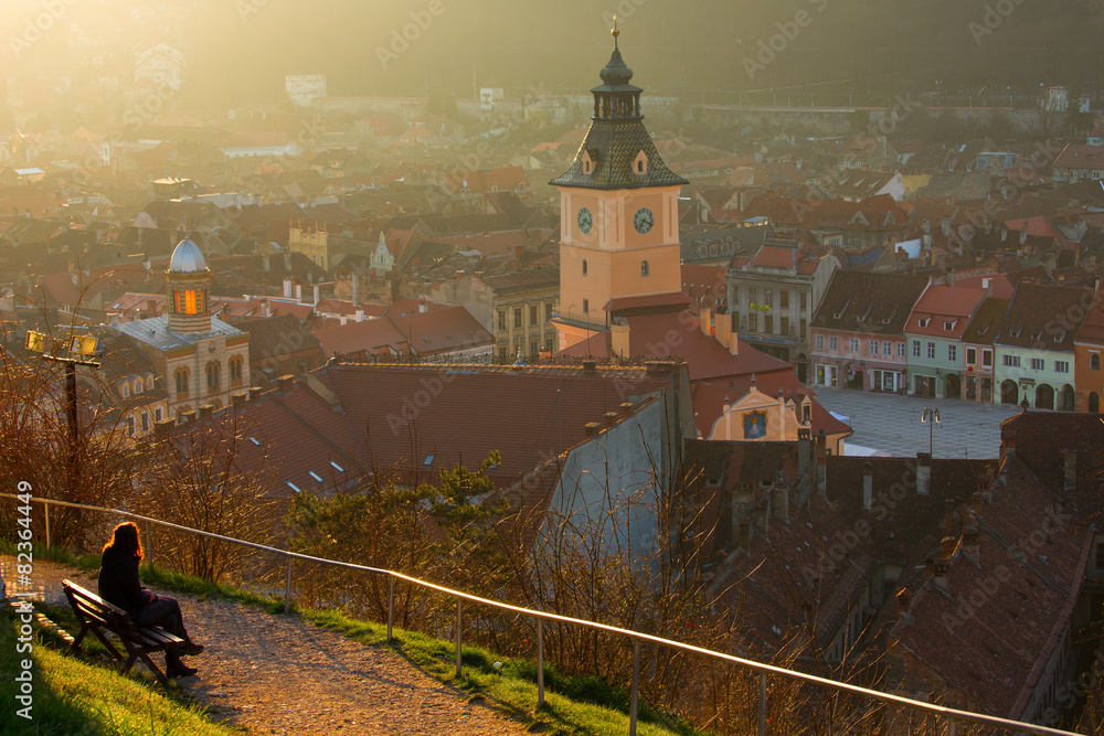Obraz premium Woman admiring th old Brasov city buildings roof, The Council Ho