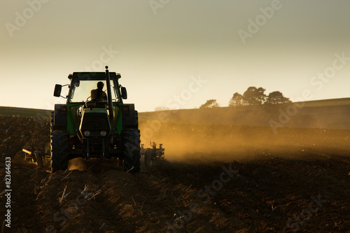 Fototapeta Traktor o zachodzie słońca orki pole
