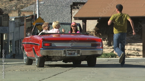 vintage red convertible driving away