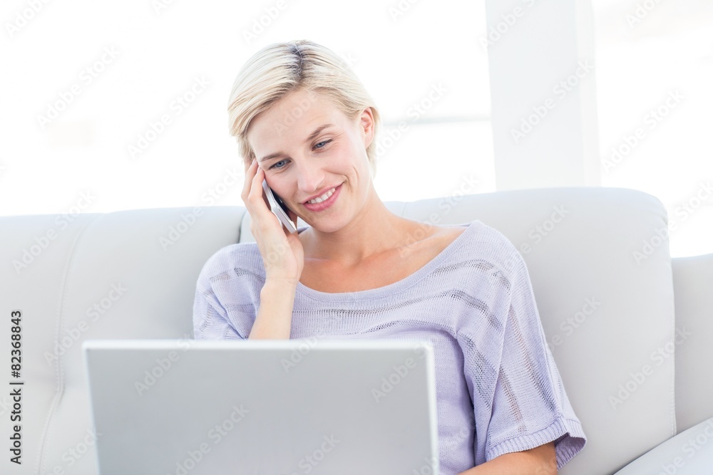 Pretty blonde woman calling on the phone and using her laptop Pretty blonde woman calling on the phone and using her laptop