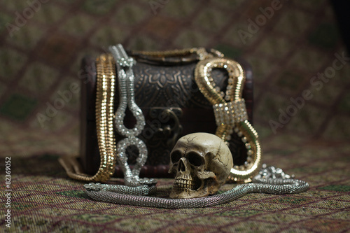Still Life skull and small box with treasures on a fabric backgr