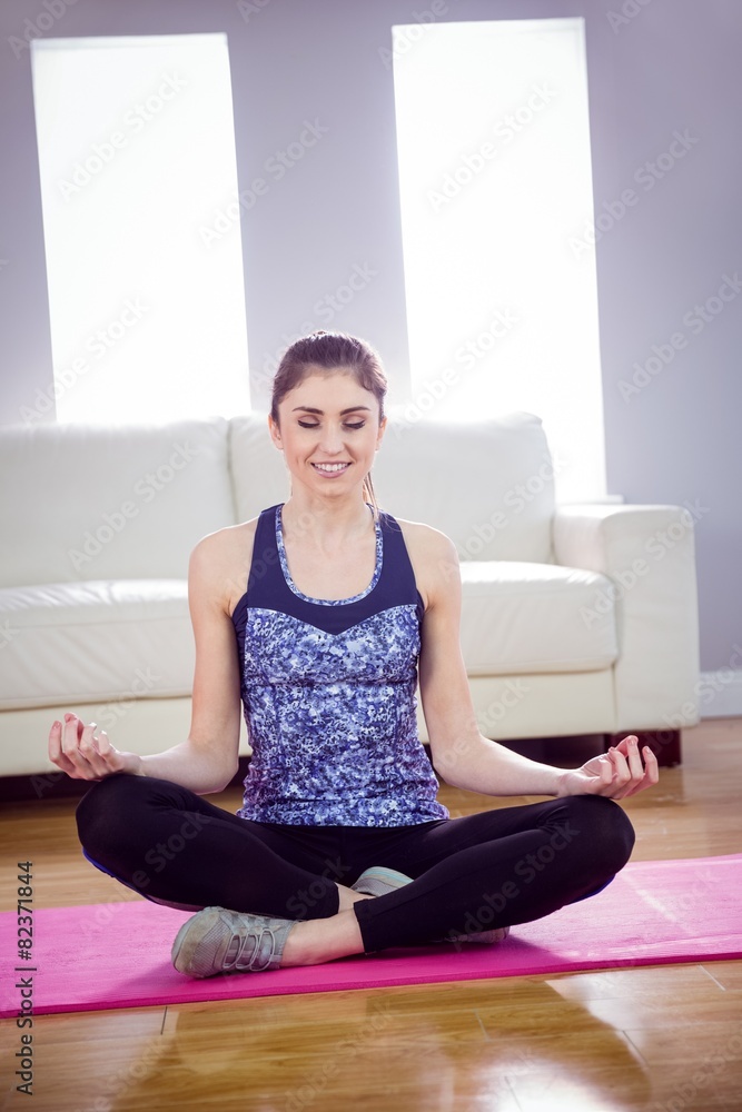Fit woman doing yoga on mat
