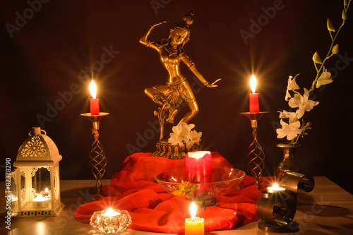 Tara, goddess statue of compassion and lit candles on altar, Buddhist Indian tradition photo