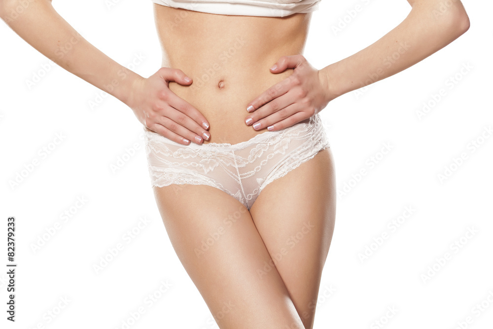 young woman holding hands on her stomach, over the ovary