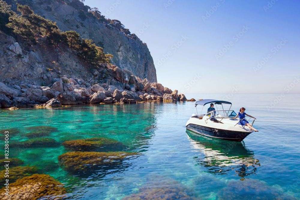Obraz premium Woman relaxing on boat in sea near shore. Traveling near island
