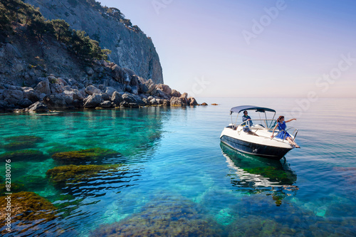 Woman relaxing on boat in sea near rocky shore. Traveling island