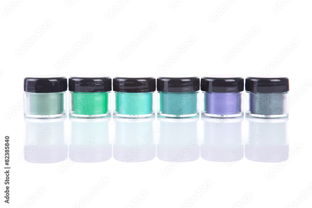 Row of green mineral eye shadows in clear plastic jars Row of green mineral eye shadows in clear plastic jars