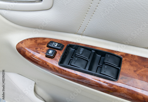 car interior details of door handle with windows controls and ad