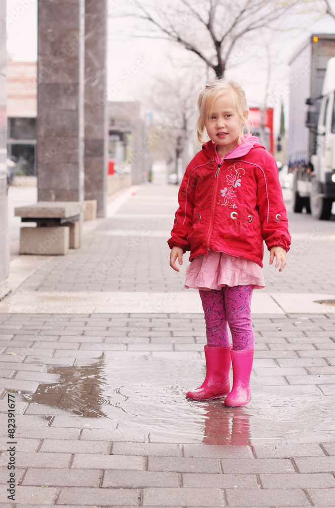 Adorable 4 years old girl at rainy day in springtime