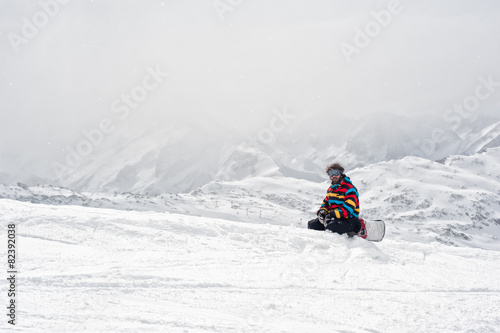 Snowboarder sit at top of mountain