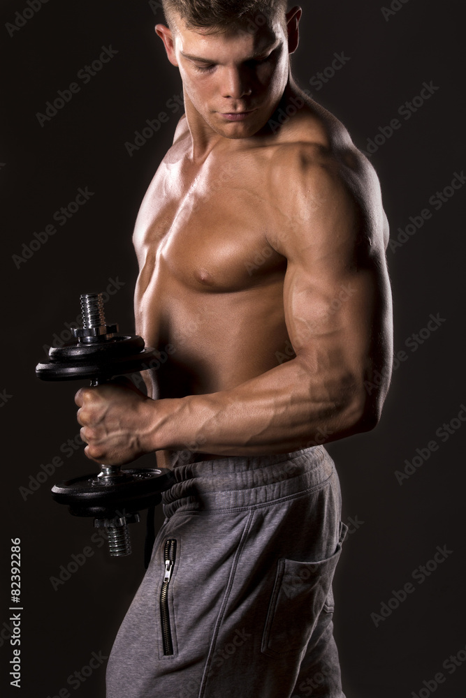 muscular bodybuilder lifting weight with one arm muscular bodybuilder lifting weight with one arm