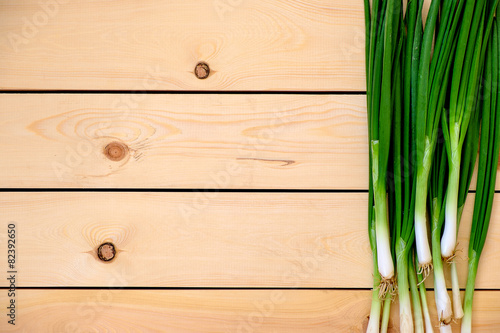 Fresh young green onions on a wooden table