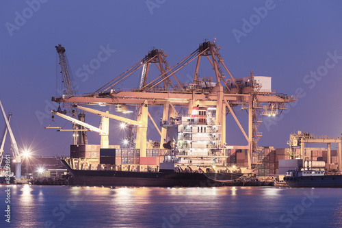 Gantry crane loading and unloading cargo container  from cargo ship at port to show global international logistics and transportation by cargo ship and cargo container  Logistic import export concept.