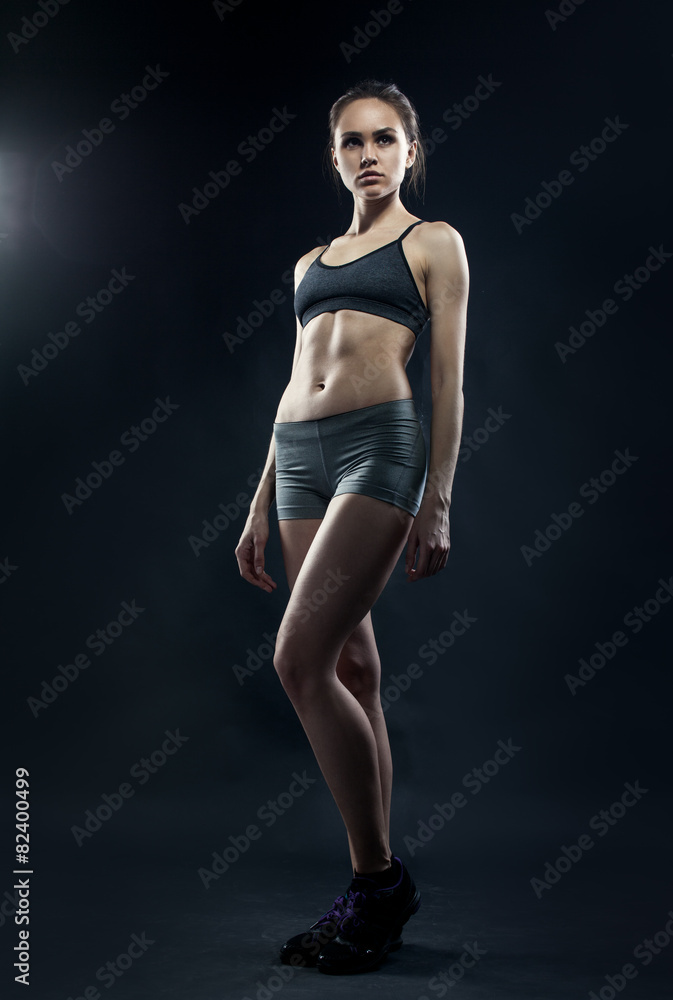 Portrait of sporty young woman with muscular body looking at cam Portrait of sporty young woman with muscular body looking at cam