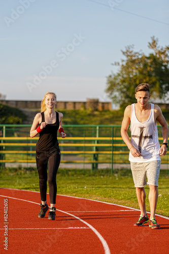 An attractive man and woman jogging on the track