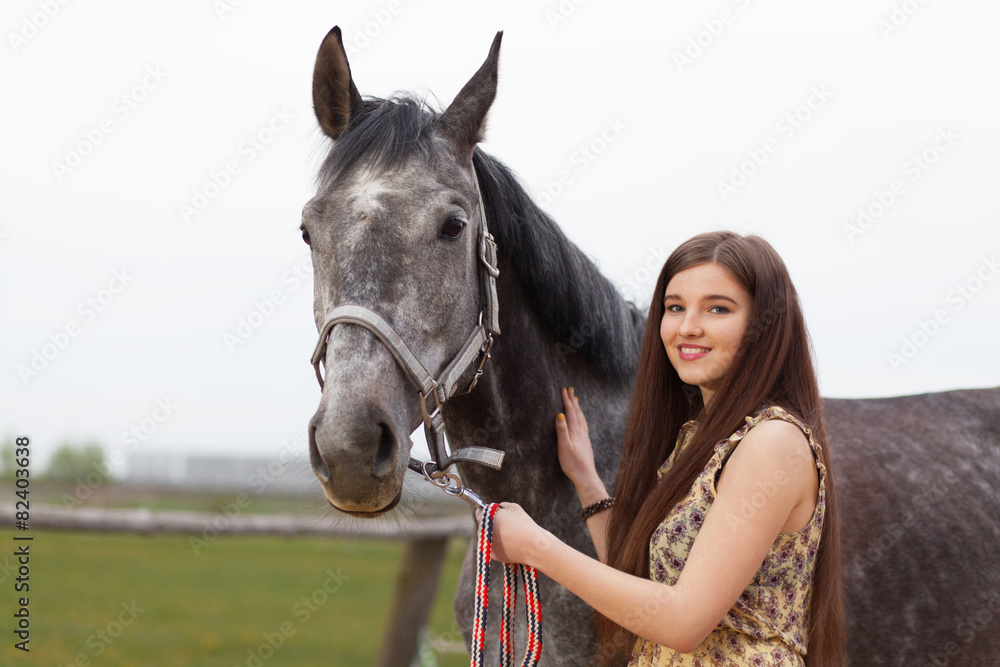 Obraz premium Young beautiful woman with a horse