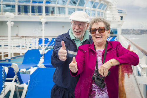 Senior Couple With Thumbs Up on Deck of Cruise Ship