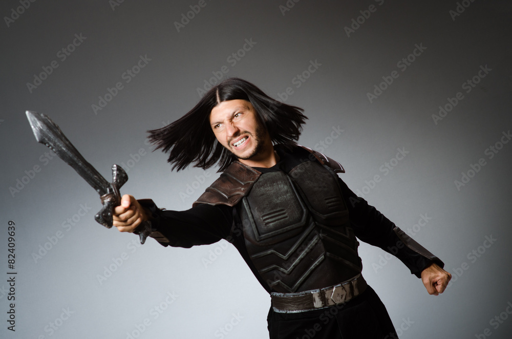 Angry knight with sword against dark background Angry knight with sword against dark background
