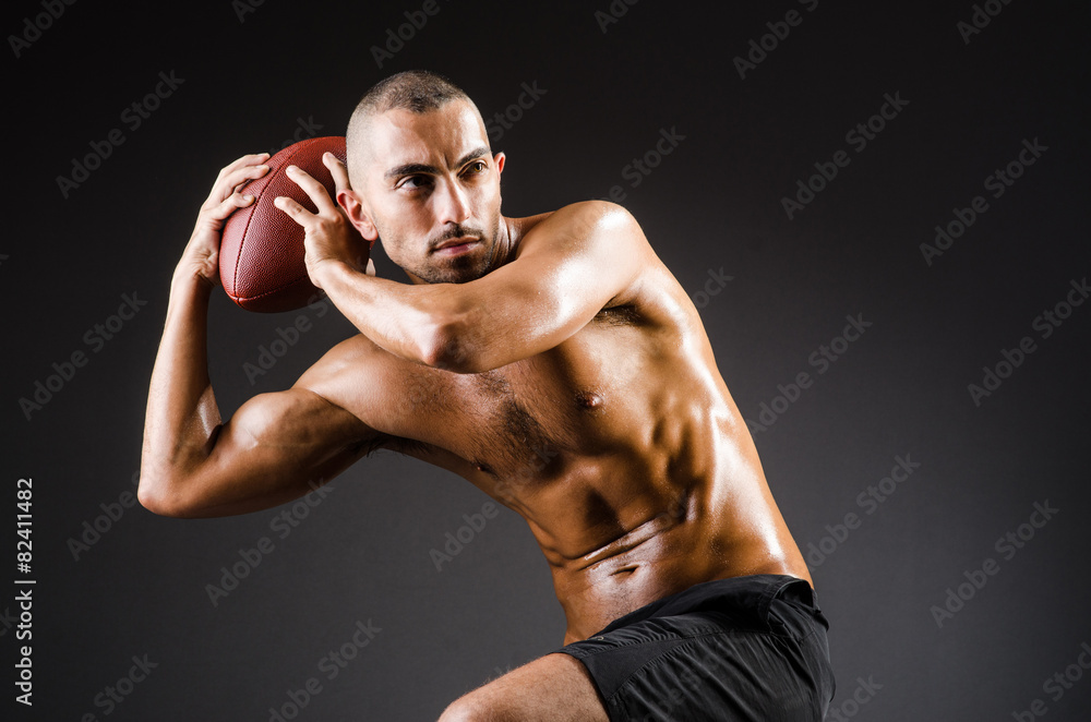 Muscular football player with ball