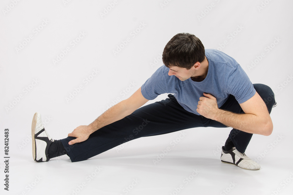 Athlete crouching pulling muscles of the right leg Athlete crouching pulling muscles of the right leg