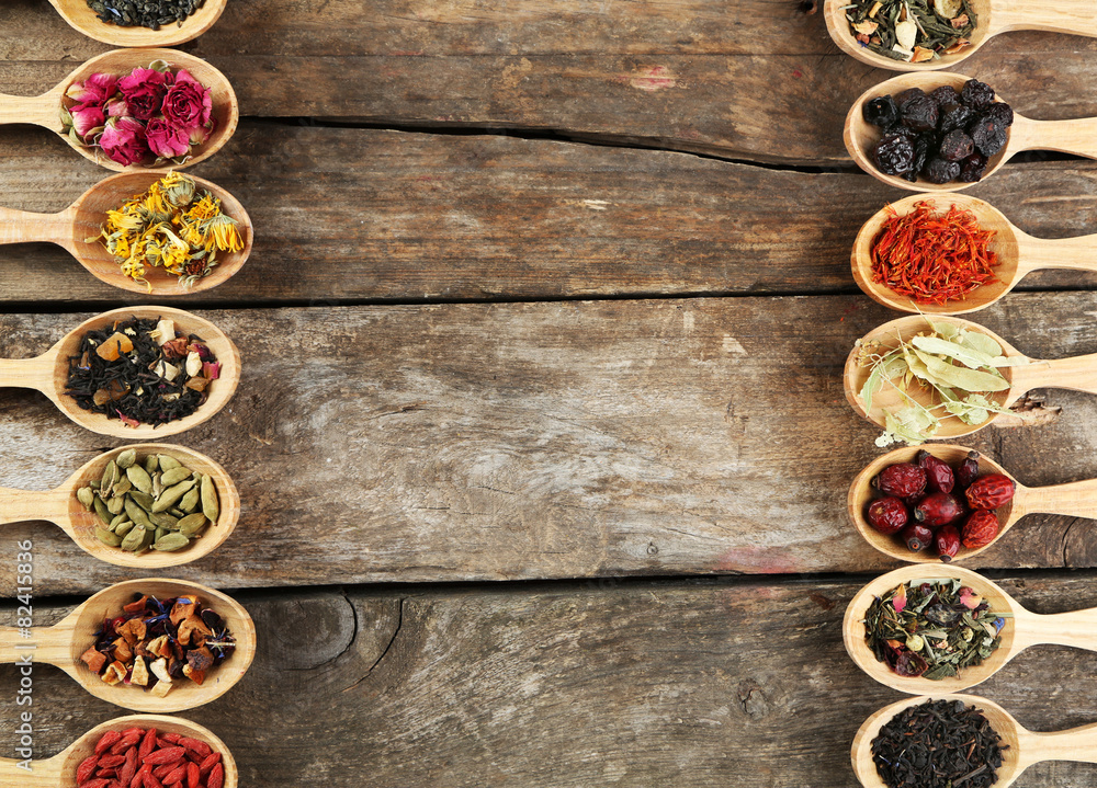 Collection of tea and natural additives in wooden spoons, on old wooden table Collection of tea and natural additives in wooden spoons, on old wooden table