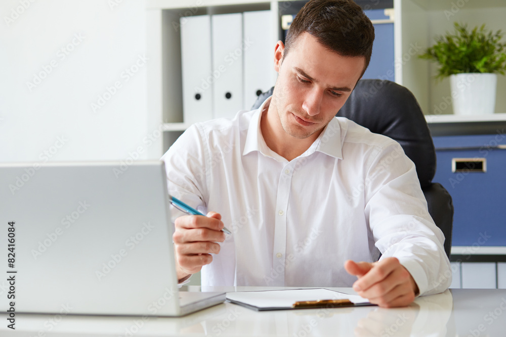 Young businessman signs a document