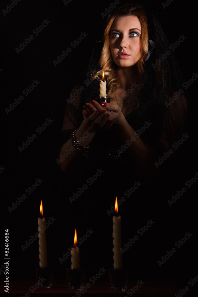 Scared young woman with a candle