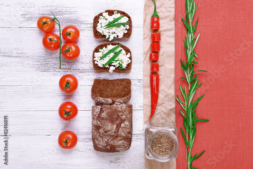 Bread with cottage cheese, greens and tomatoes on table top view