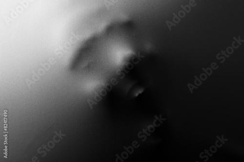 Obraz na plátně Screaming human face pressing through fabric as horror background