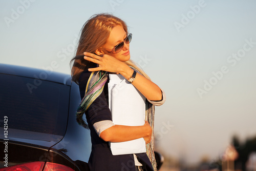 Fashion business woman with financial papers next to her car