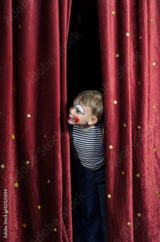 Boy Dressed Up as Clown Peeking Thru Stage Curtain