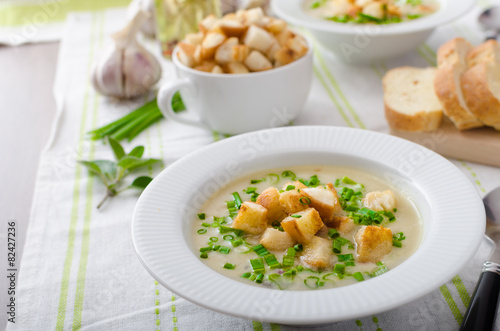 Garlic soup with croutons, spring onions and chives