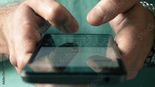 Close- up hands typing text messages on smart phone