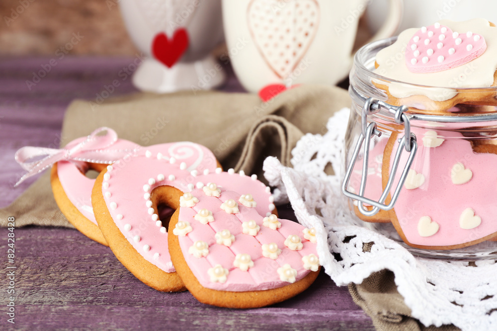 Heart shaped cookies for valentines day, teapot and cups on color wooden background Heart shaped cookies for valentines day, teapot and cups on color wooden background