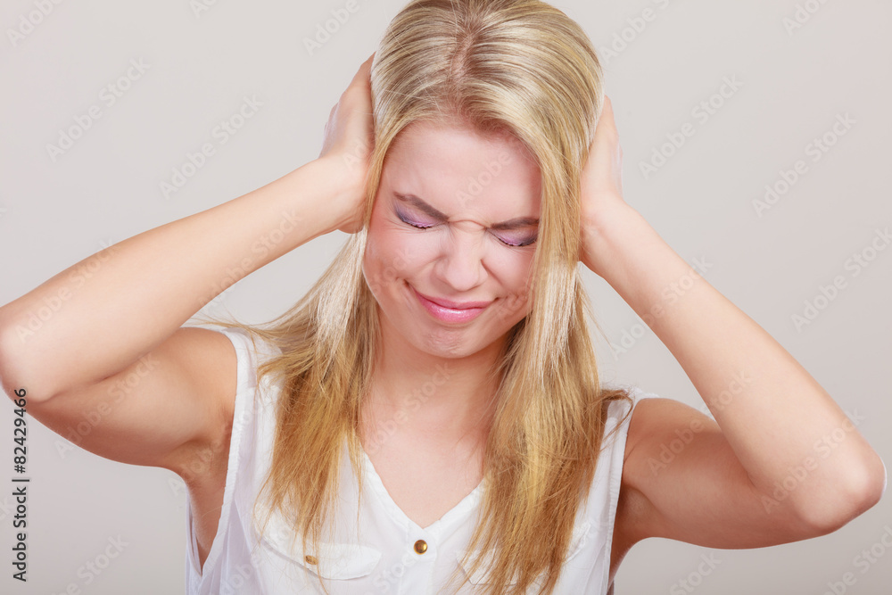 Closeup stressed business woman covers ears with hands Closeup stressed business woman covers ears with hands